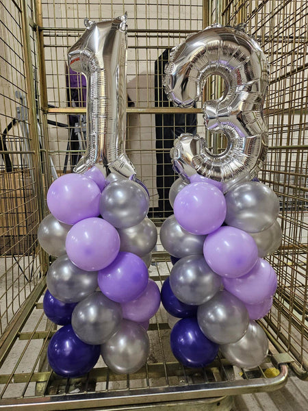 Decorative balloons in silver, purple, and blue inside a shopping cart.